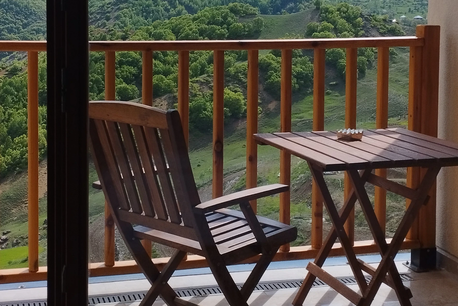 Karlı dağlara bakan balkon sandalyesi ve masası