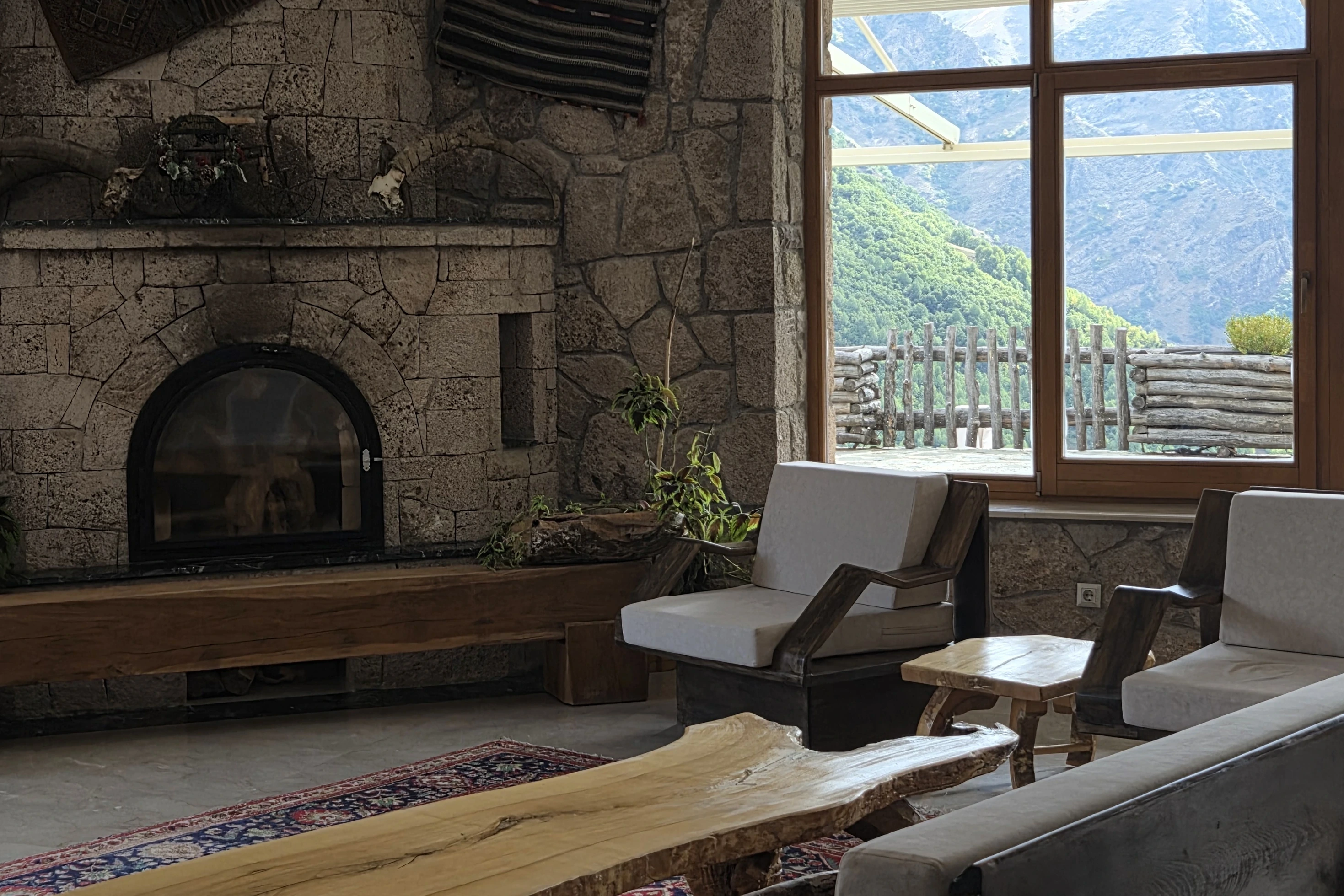 Taş şömineli ve dağ manzaralı salon