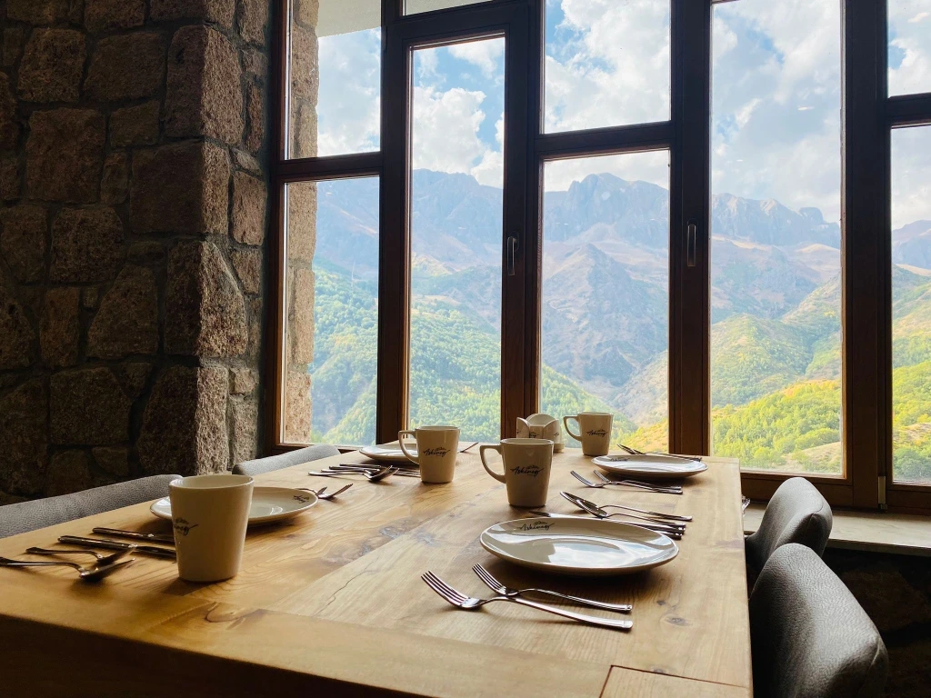 Pencere önünde kahvaltı için kurulmuş restoran masaları