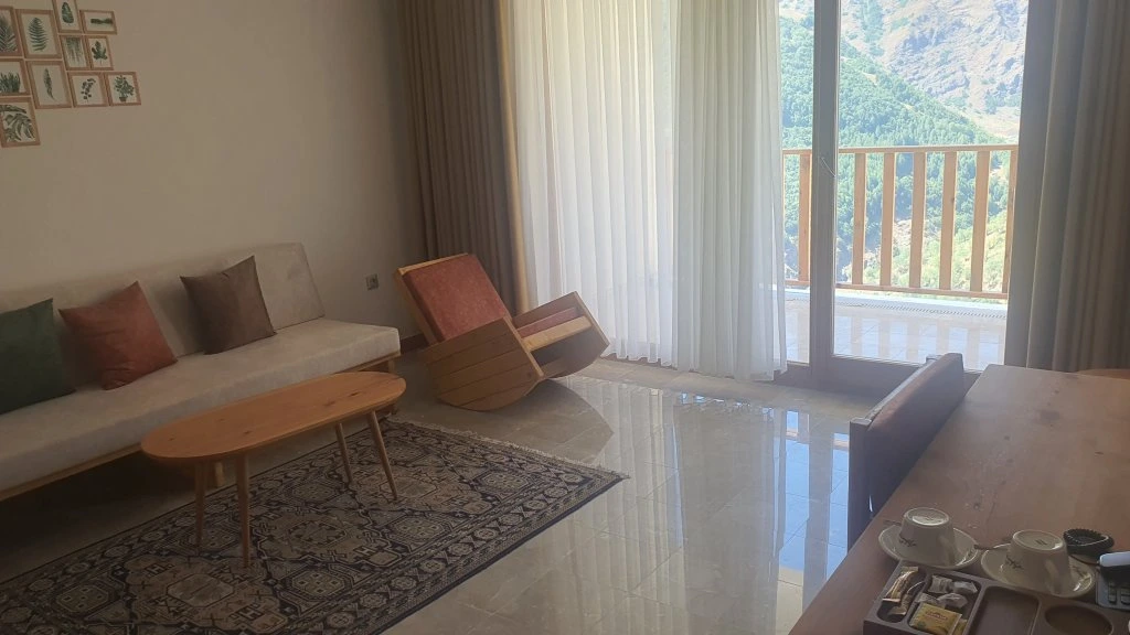 Kanepeli süit oturma alanı ve dağlara bakan balkon