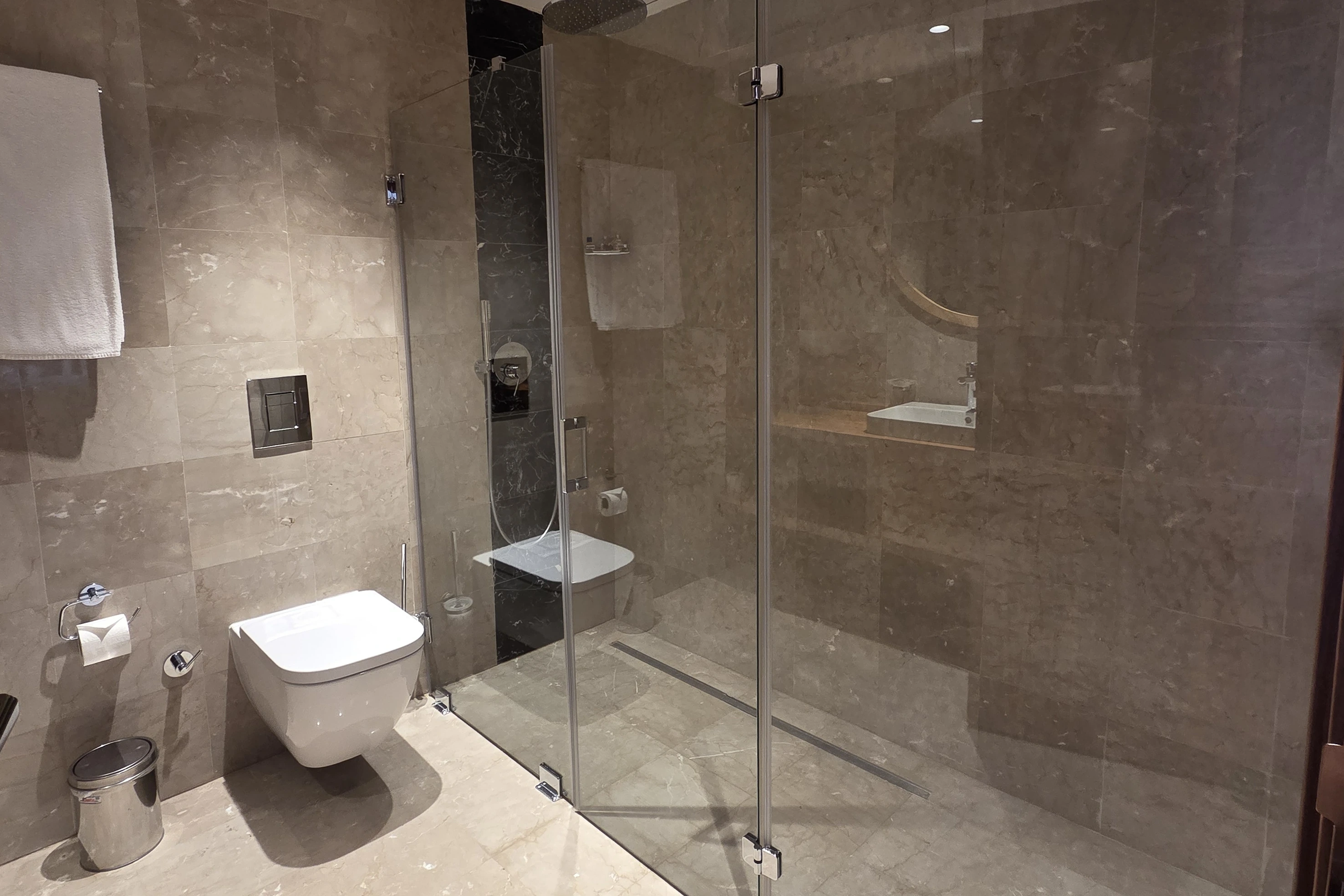 Cam duşakabinli ve taş kaplamalı banyo