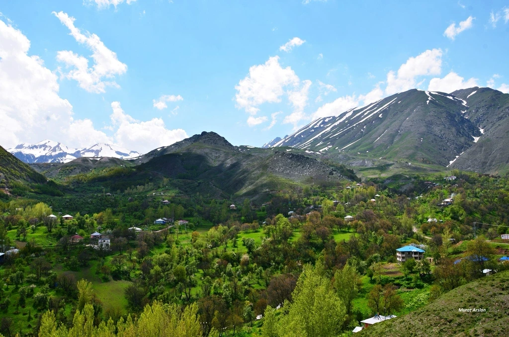 Karlı dağların eteğinde köyüyle yeşil bir vadi