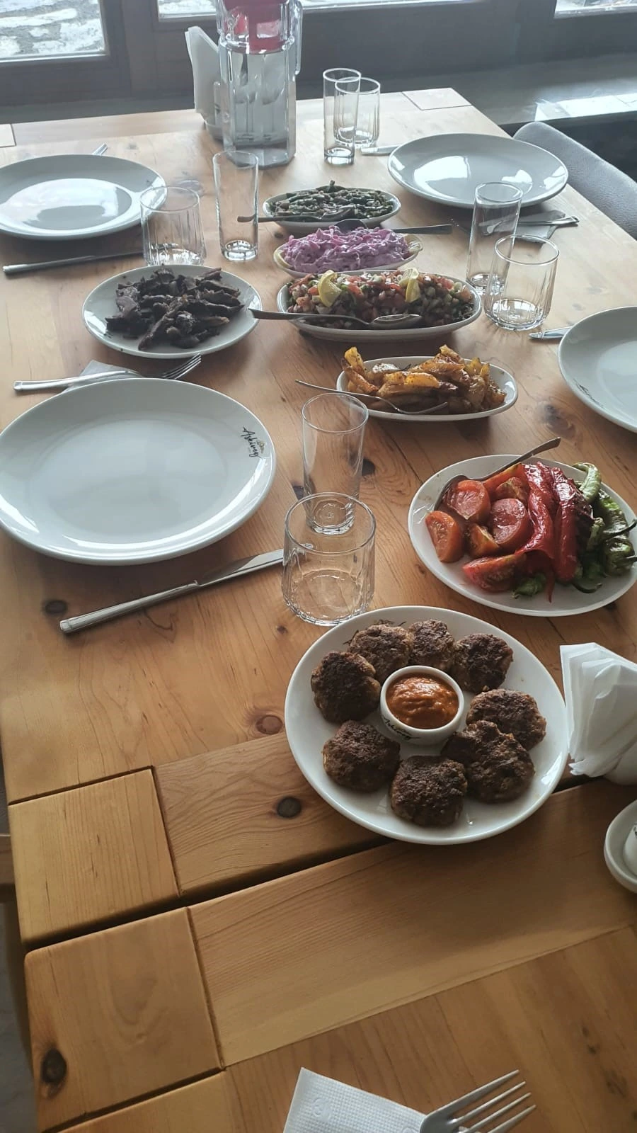 Meze, salata ve köfteyle kurulmuş masa